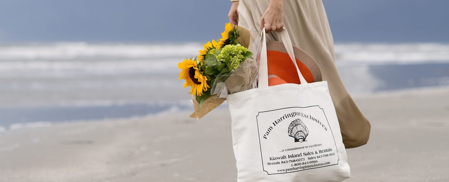 Woman holding a Pam Harrington Exclusives branded tote with sunflowers