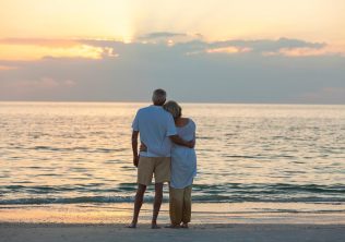 Retired Couple Looking at Sunset from the beach