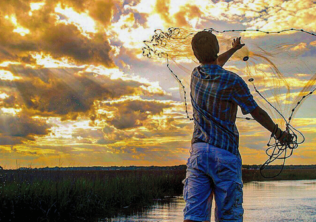 Casting a net with a Johns Island sunset in the background