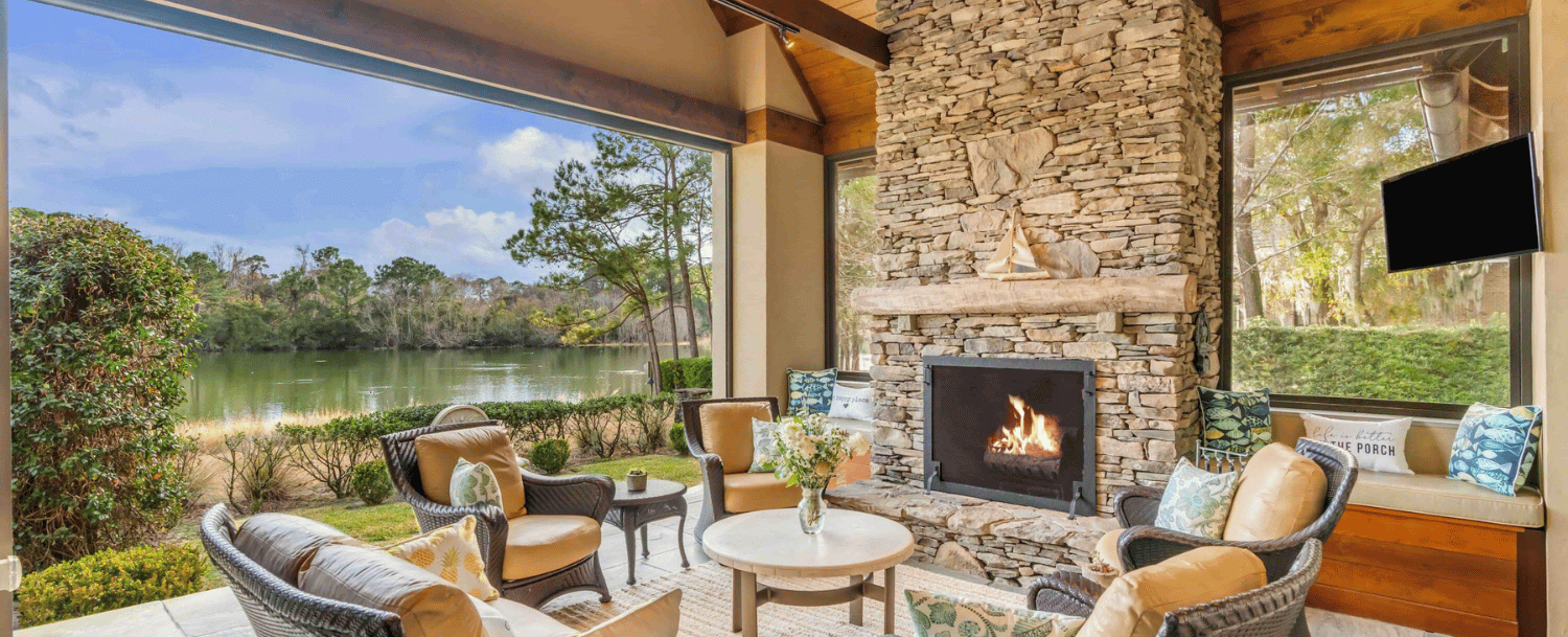 Outdoor living area with fireplace overlooking lagoon on Johns Island SC