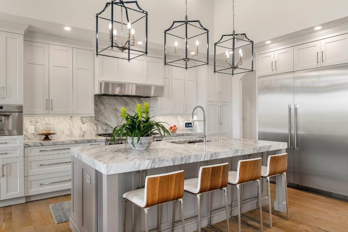 Gourmet kitchen with Italian marble island, pendant lighting, and stainless appliances at 6411 China Back Lane, Meggett SC — Archfield Plantation