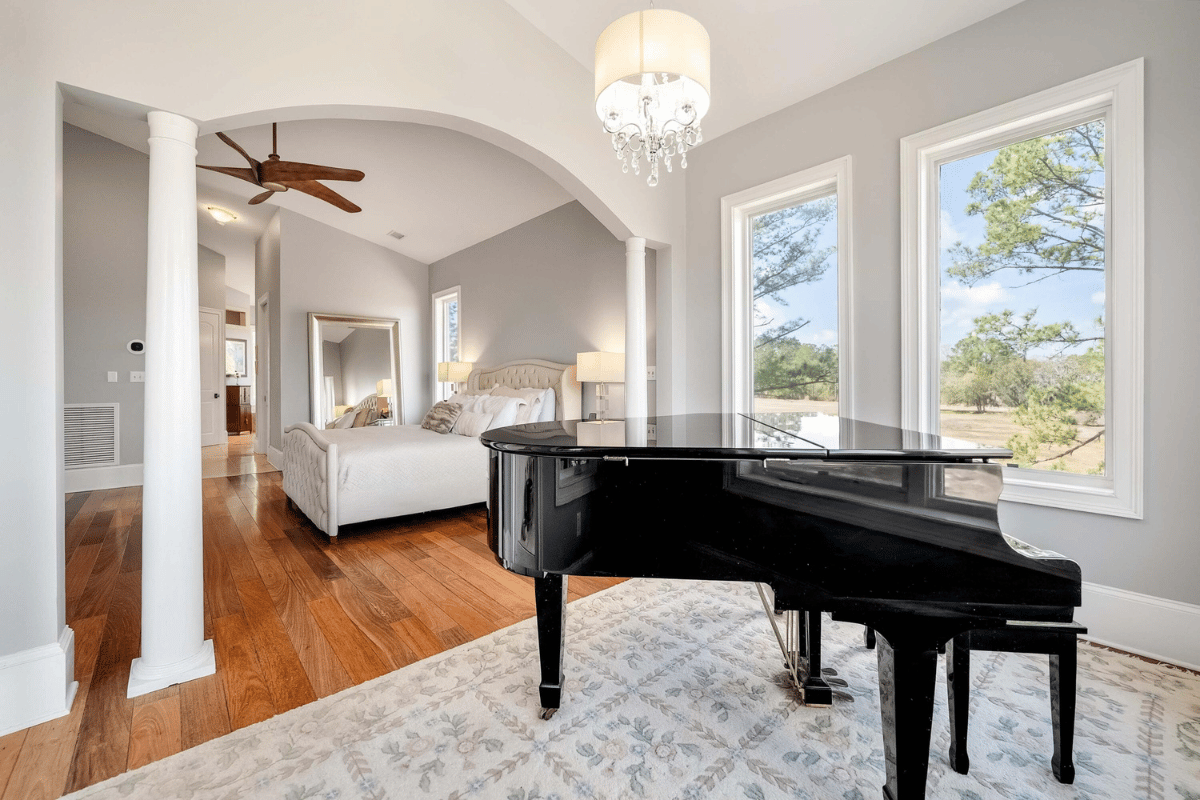 Primary suite with hardwood floors, vaulted ceiling, arched sitting room, and marsh views at 6411 China Back Lane, Meggett SC