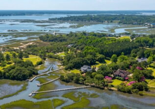 Aerial view of private dock and boardwalk extending through Lowcountry marsh on Oyster House Creek at 6411 China Back Lane, Meggett SC — Archfield Plantation
