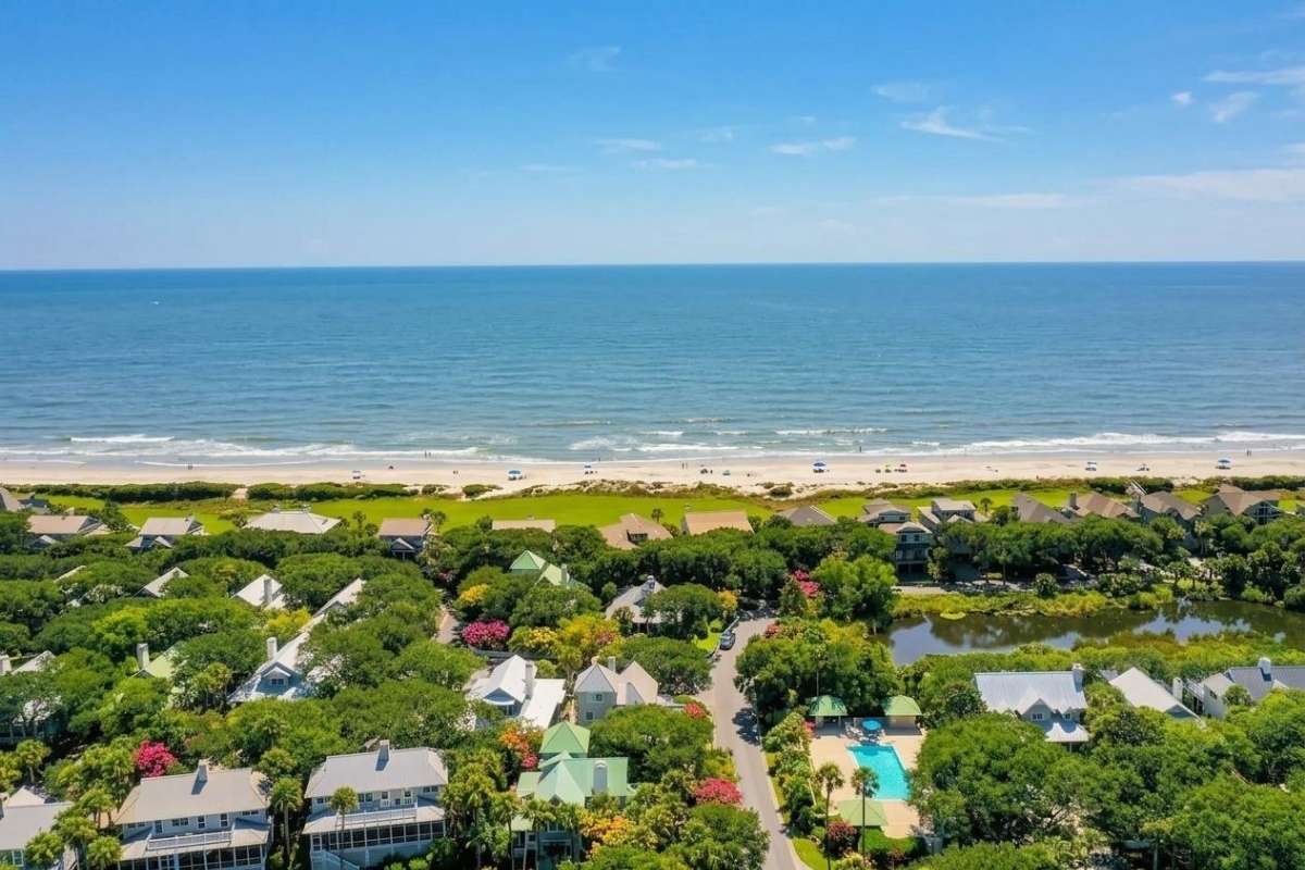 Aerial view of The Enclave at Turtle Beach showing homes, community pool, and Atlantic shoreline, Kiawah Island