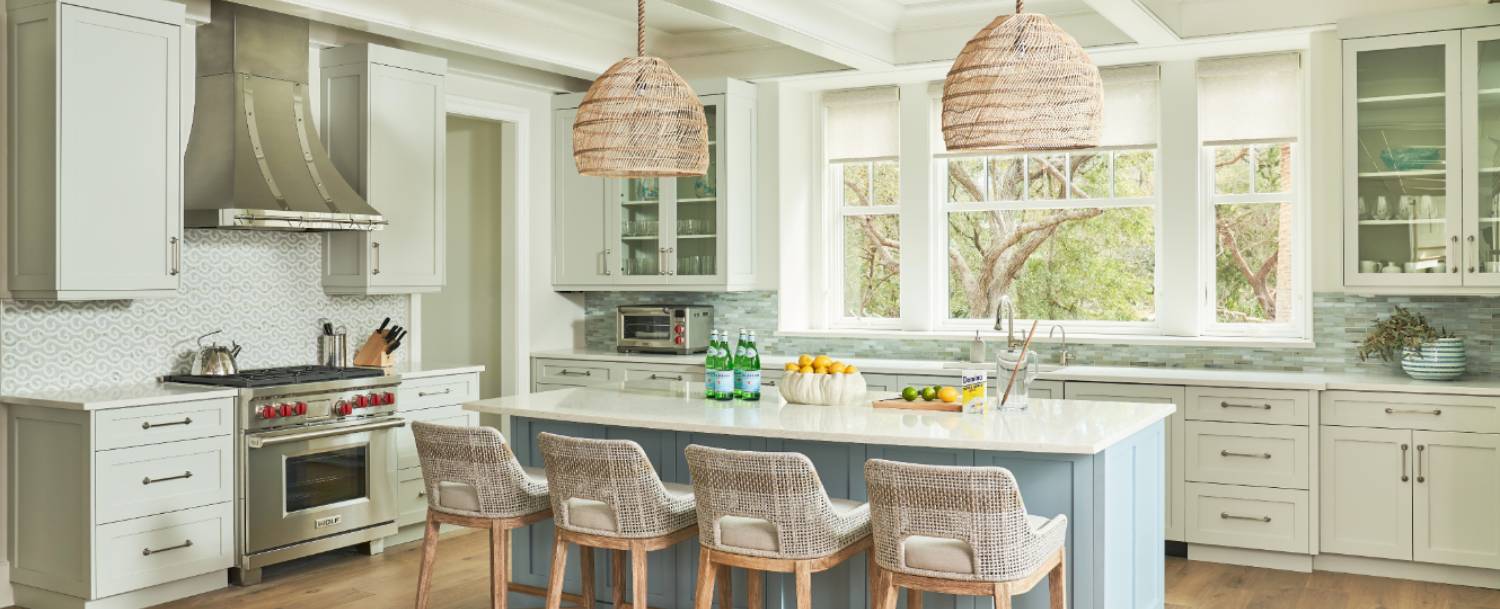 Custom kitchen interior of an Ocean Park home on Kiawah Island with Wolf range, wicker pendants, and live oak views