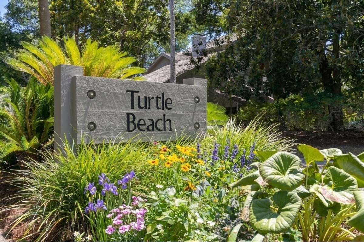 Turtle Beach neighborhood entrance sign surrounded by flowering plants and subtropical landscaping, Kiawah Island