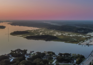 Aerial view of the Stono River, tidal marsh, and Maybank Highway bridge on Johns Island, South Carolina at dusk