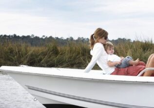 A multigenerational family relaxing on a boat in the Kiawah Island marshes