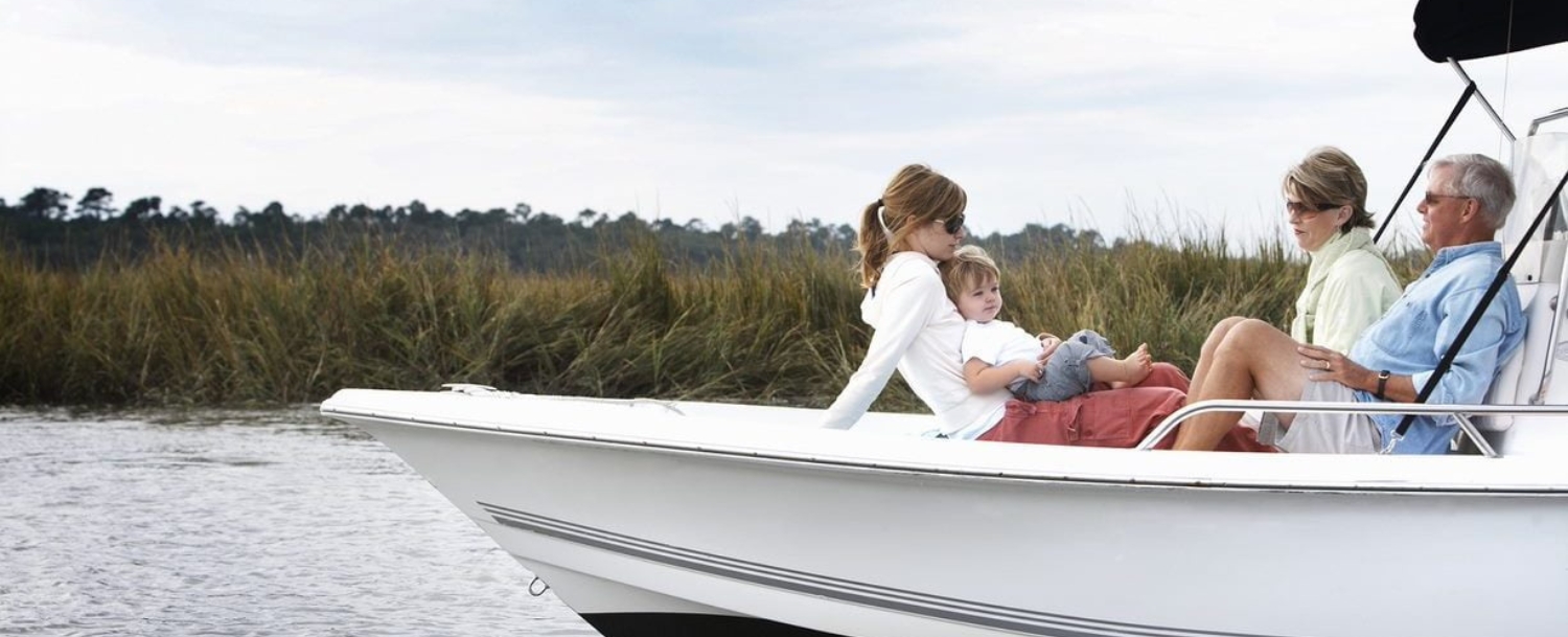 A multigenerational family relaxing on a boat in the Kiawah Island marshes