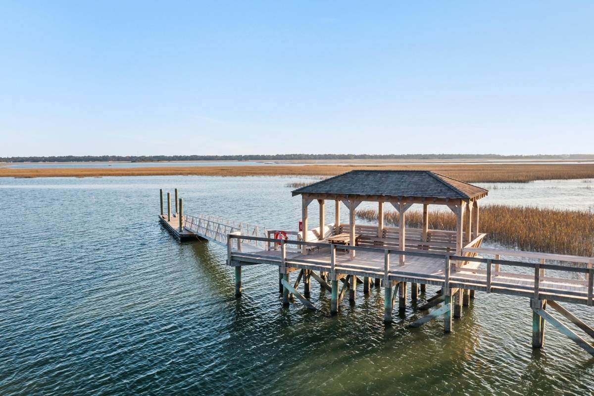 Covered dock gazebo with floating dock, marsh grass, and open water at Kiawah River community on Johns Island SC