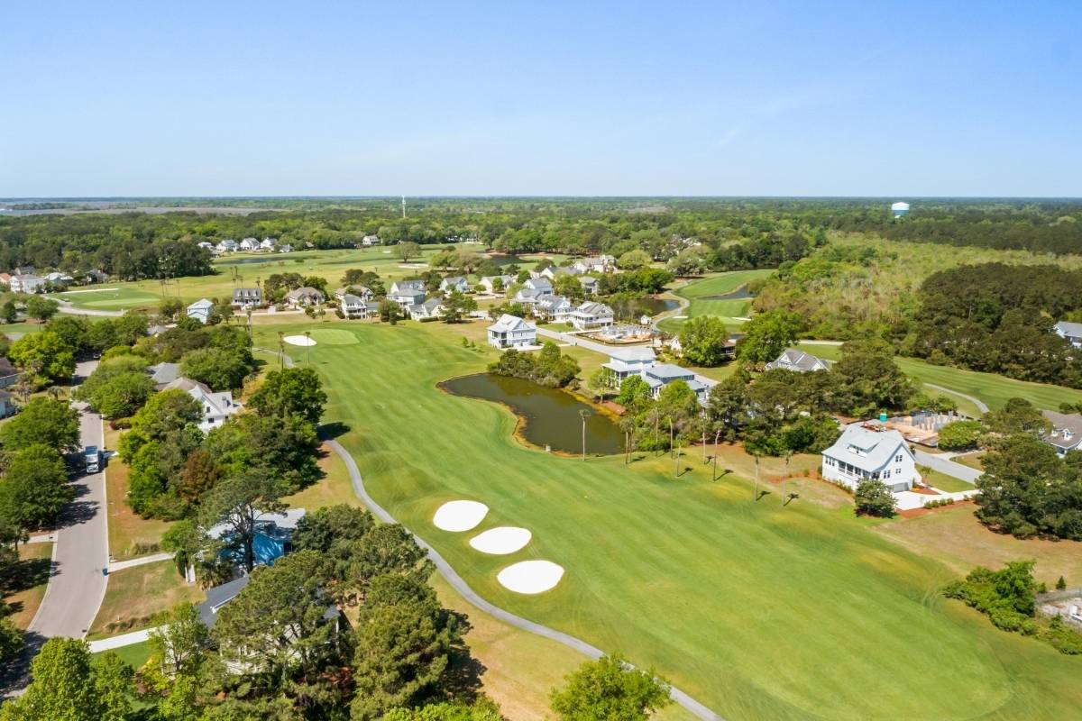 Aerial view of Oak Point golf course fairway with sand bunkers, pond, and homes at Kiawah River Estates on Johns Island SC