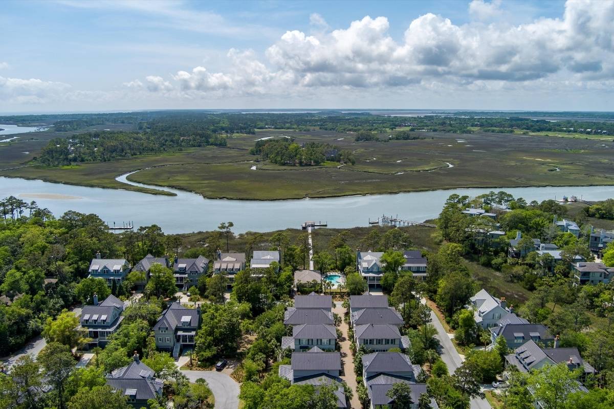 Aerial view of Riverview community homes along a tidal river bend with expansive marsh and community dock, Kiawah Island SC