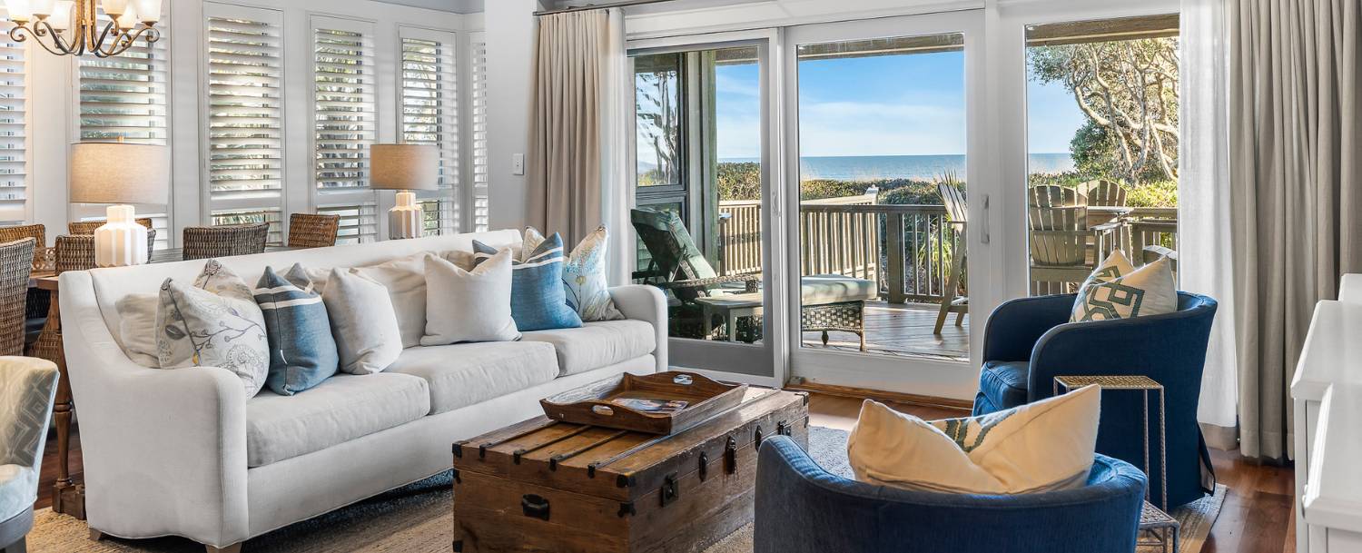 Oceanfront living room in a Seascape Villa on Kiawah Island, with ocean views through sliding glass doors opening to a furnished deck