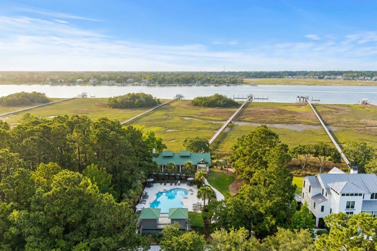 Aerial view of Rushland Landing on Johns Island, SC, showing the community pool, pavilion, dual dock walkways extending through marsh to the Stono River